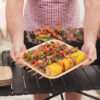 Stack of heavy duty palm leaf plates set with colorful BBQ food, showing natural texture and sturdy edges
